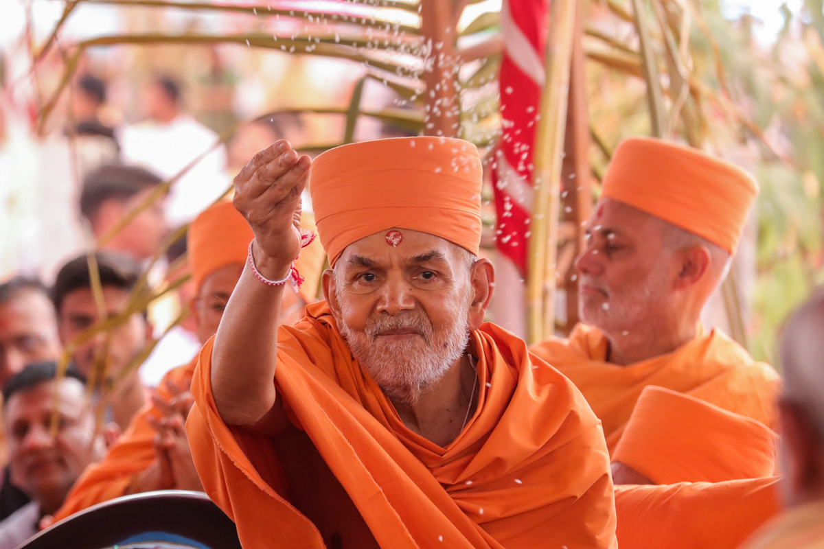 Swamishri blesses all by showering rice grains