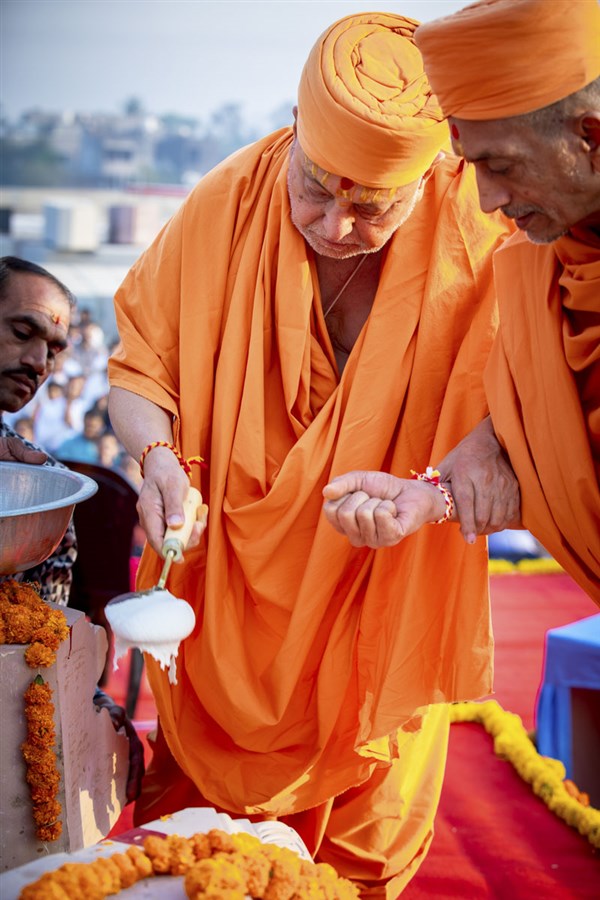 Pujya Ishwarcharan Swami pours cement mixture