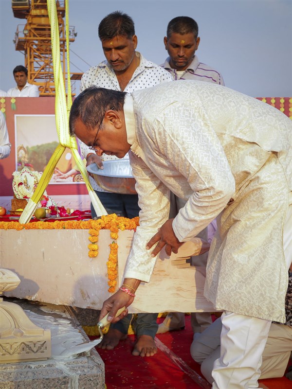 A devotee pours cement mixture