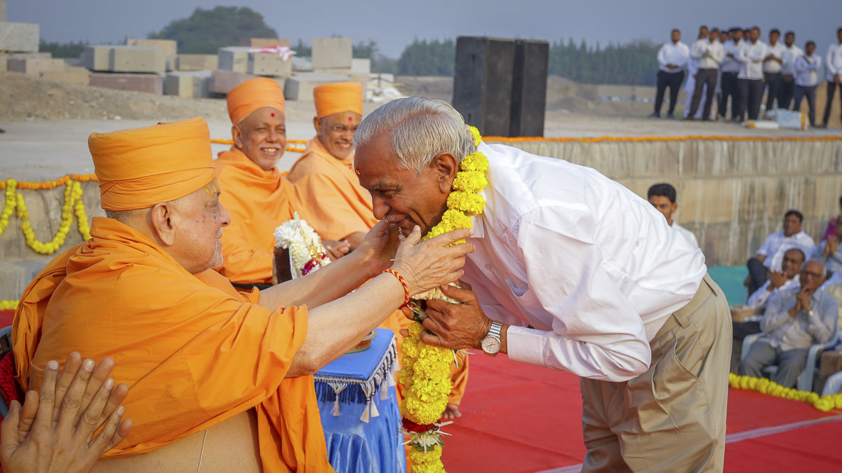 Pujya Ishwarcharan Swami honors Shri Harshadbhai Chavda with a garland