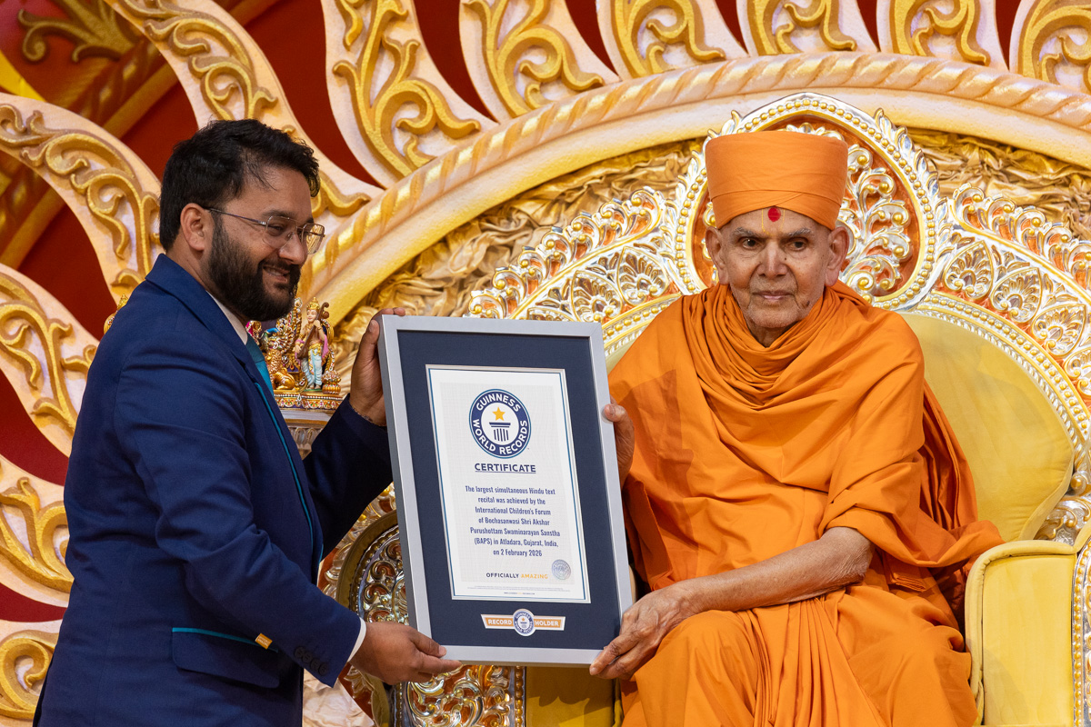Shri Swapnil Dangarikar presents a Guinness World Record certificate to Swamishri for 'Largest Simultaneous Hindu Text Recital'