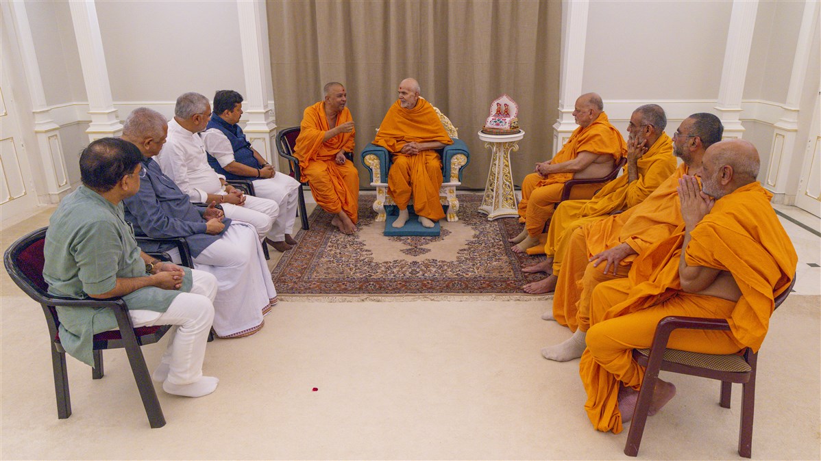 Dignitaries in conversation with Mahant Swami Maharaj, Pujya Ishwarcharan Swami and senior swamis