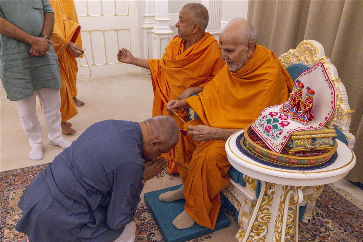 Swamishri blesses with a mala to Shri B.L. Santhosh