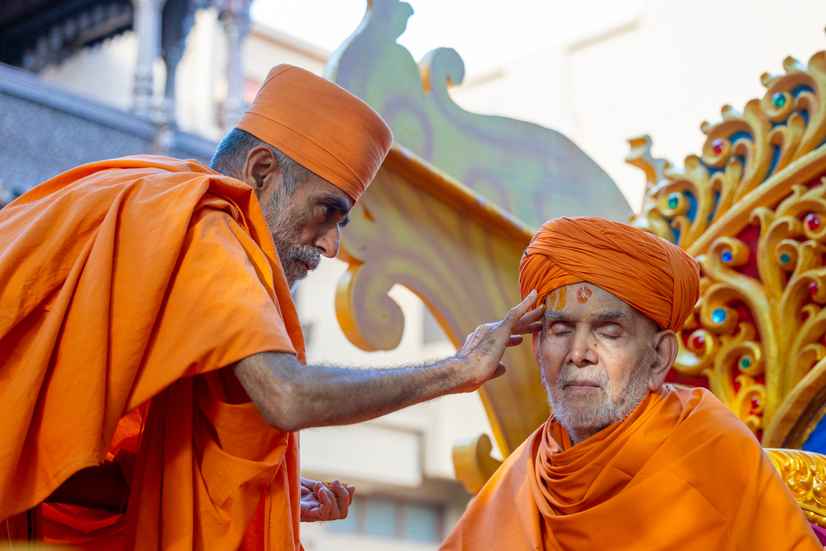 Pujya Anandswarup Swami applies chandan archa to Swamishri