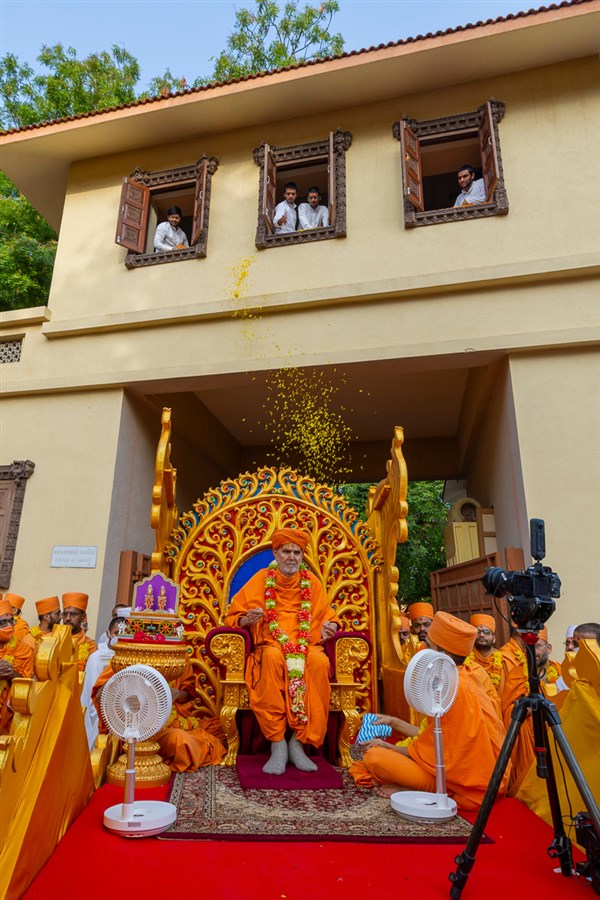 Youths shower flower petals on Swamishri