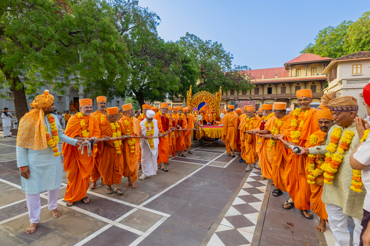 Swamis and devotees pull the chariot of Swamishri